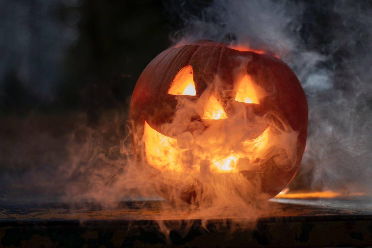 Scary face on a pumpkin with smoke around it